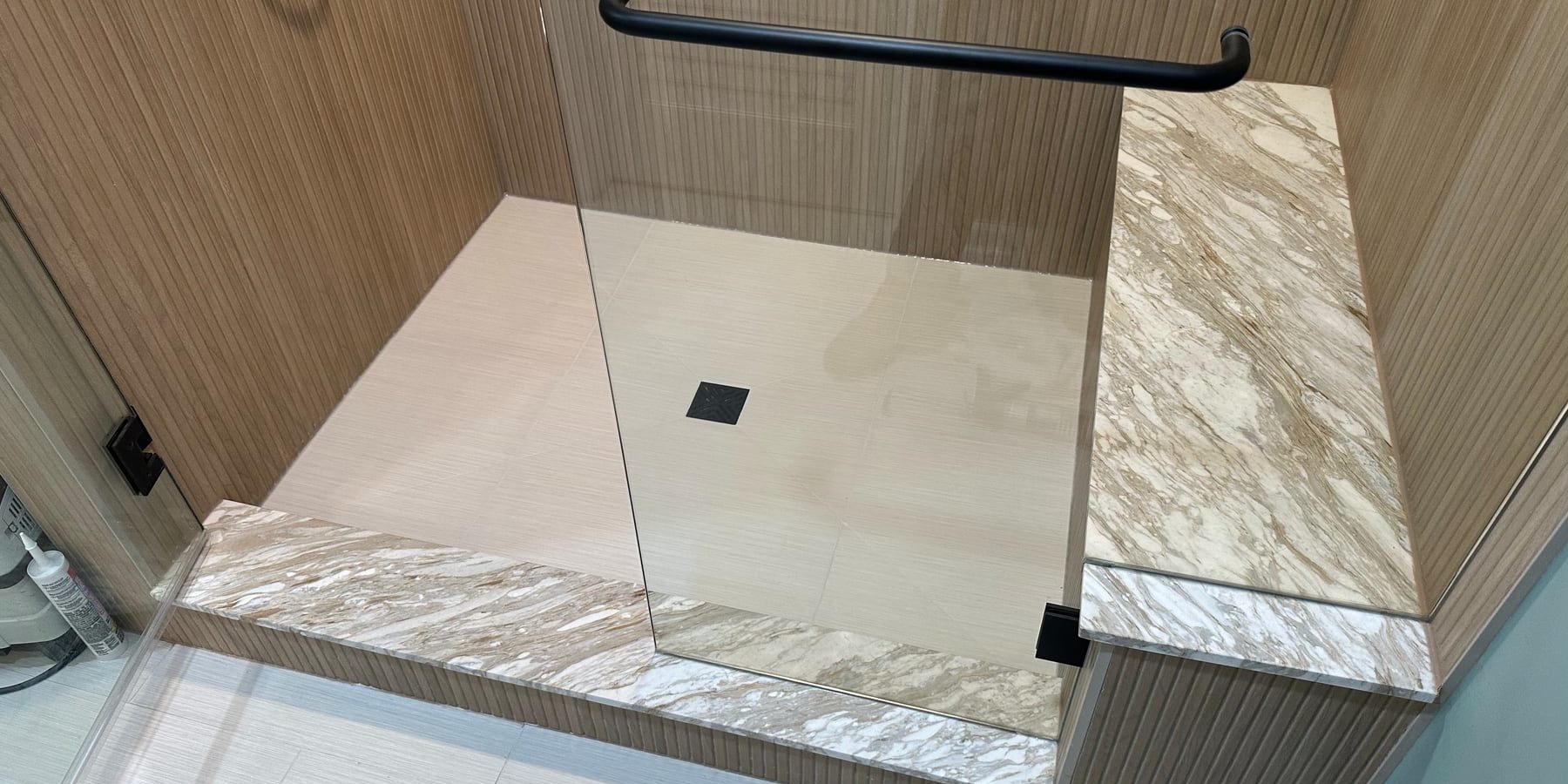 Completed modern tile shower-floor repair with square drain and preserved stone finishes in Highland Park
